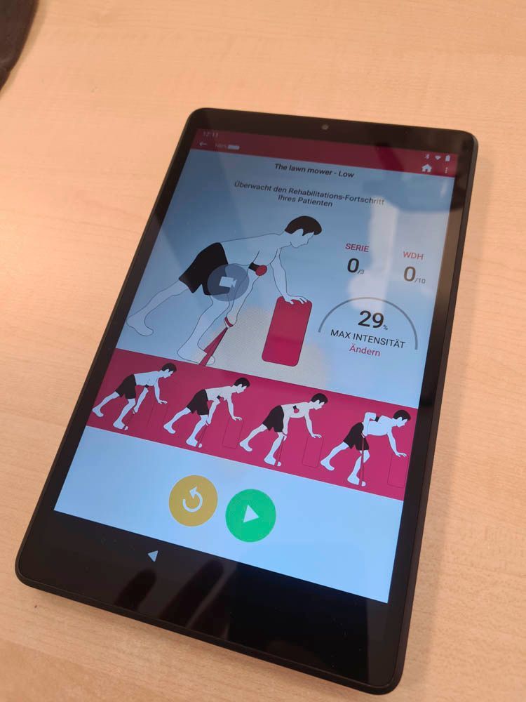 Auf einem Schreibtisch steht ein Tablet, auf dem eine Fitness-App mit einem Comic-Läufer