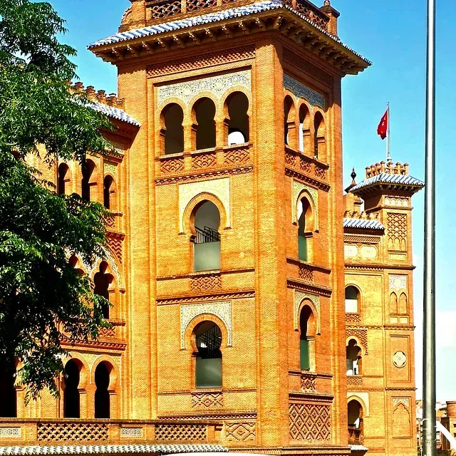 Un edificio alto de ladrillo con una bandera roja en la parte superior
