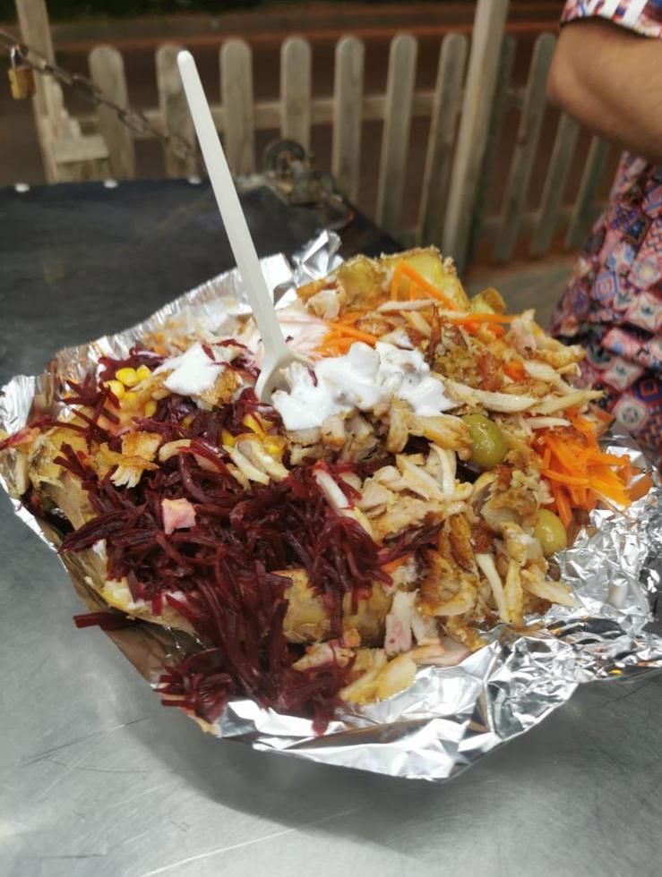 Shawarma en bandeja de aluminio, cubierto con remolacha, zanahoria, maíz y yogur.