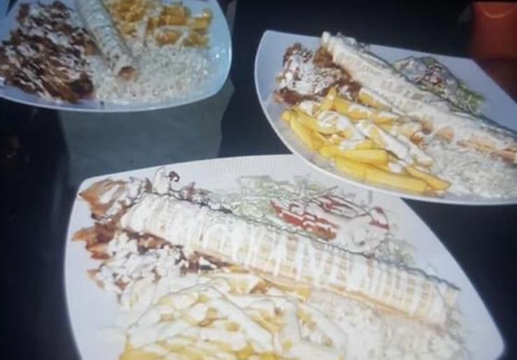 Tres platos de comida con salsa blanca, papas fritas y wraps.