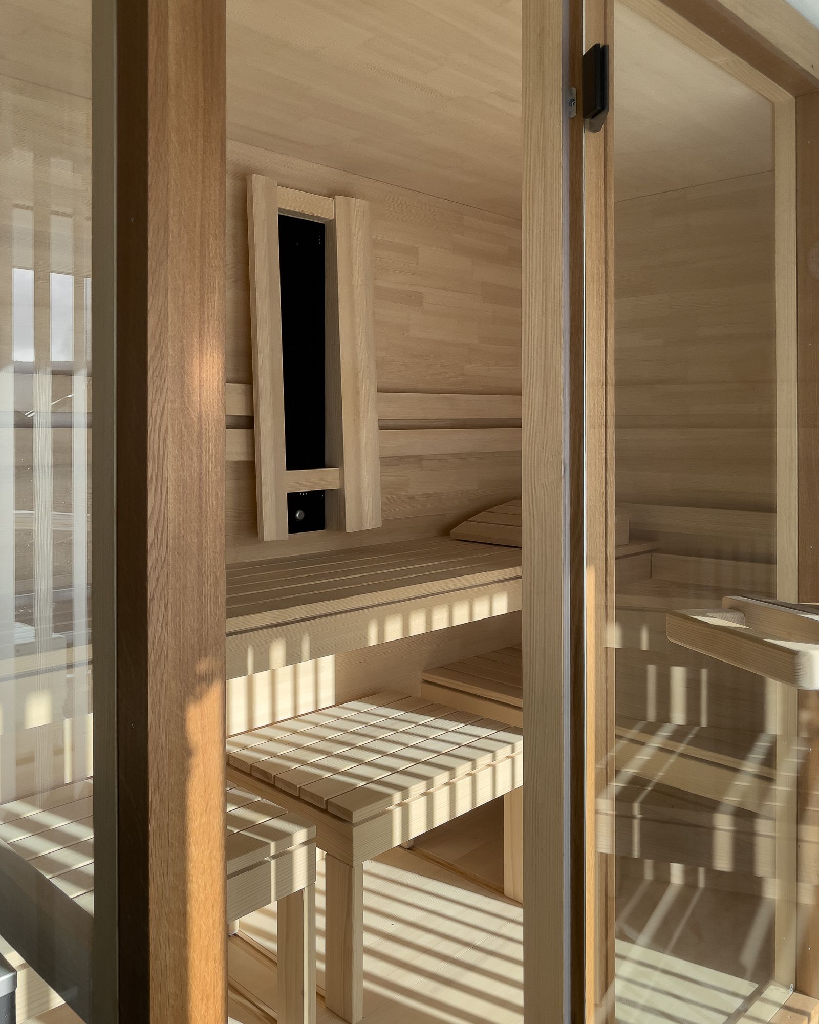 Exklusive Sauna mit Glasfront und Holzinterieur von Schreinerei Tritschler