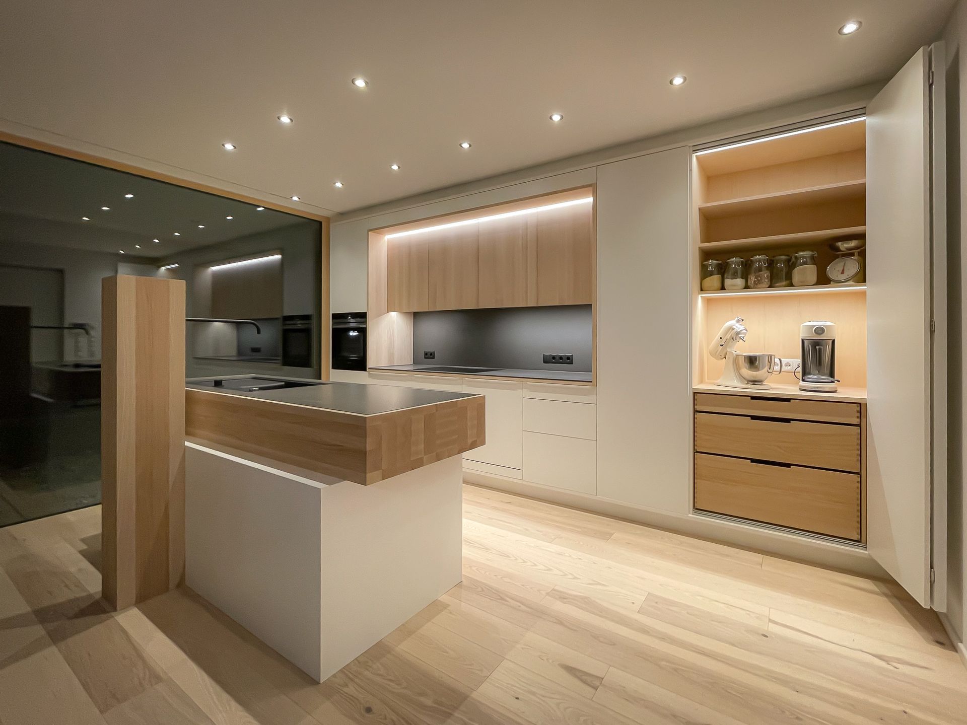 Moderne Designküche nach Maß von Schreinerei Tritschler mit Kochinsel und LED-Beleuchtung