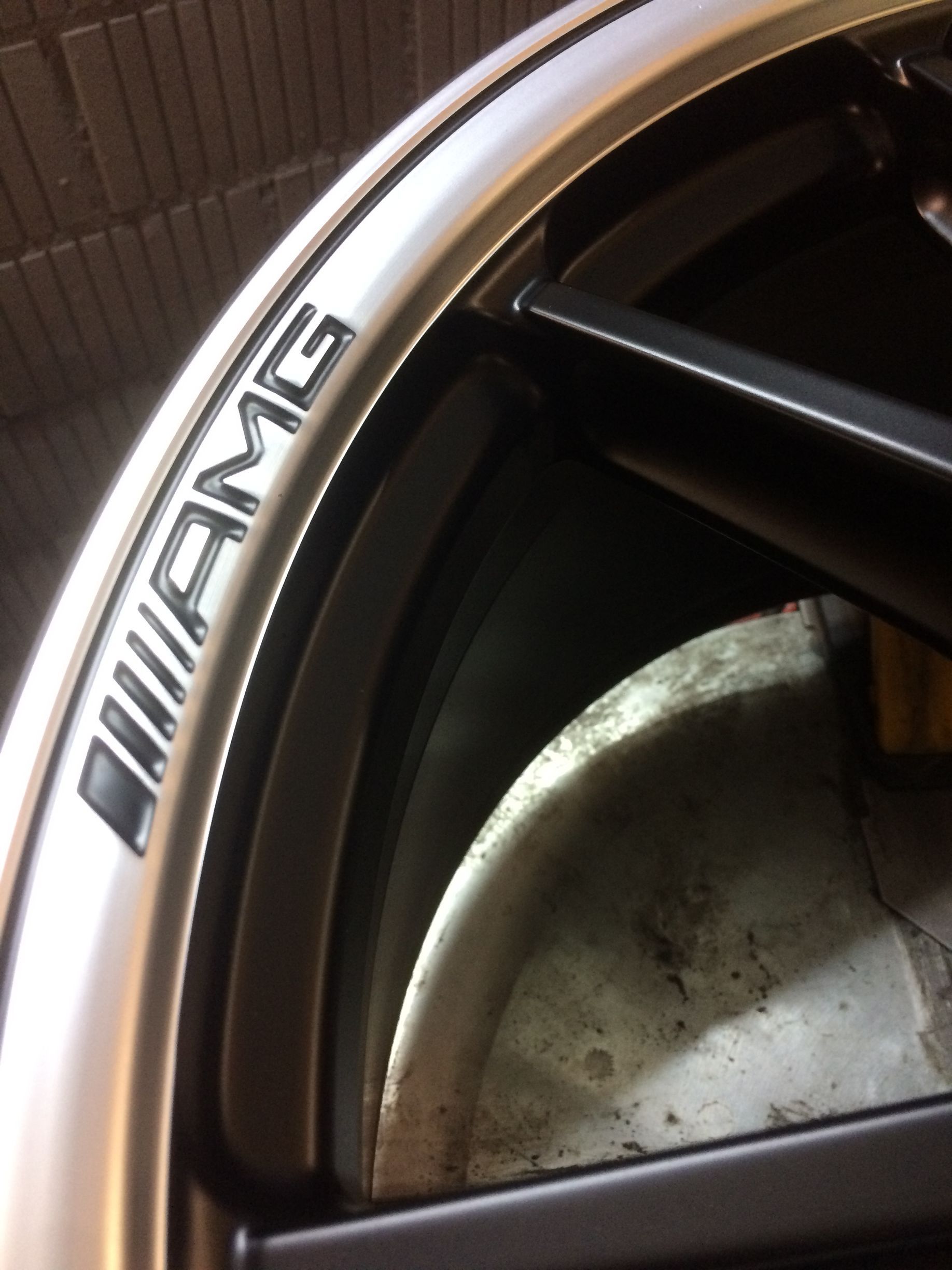 Silberne AMG-Felgendetails, schwarze Speichen, Felgenbranding.