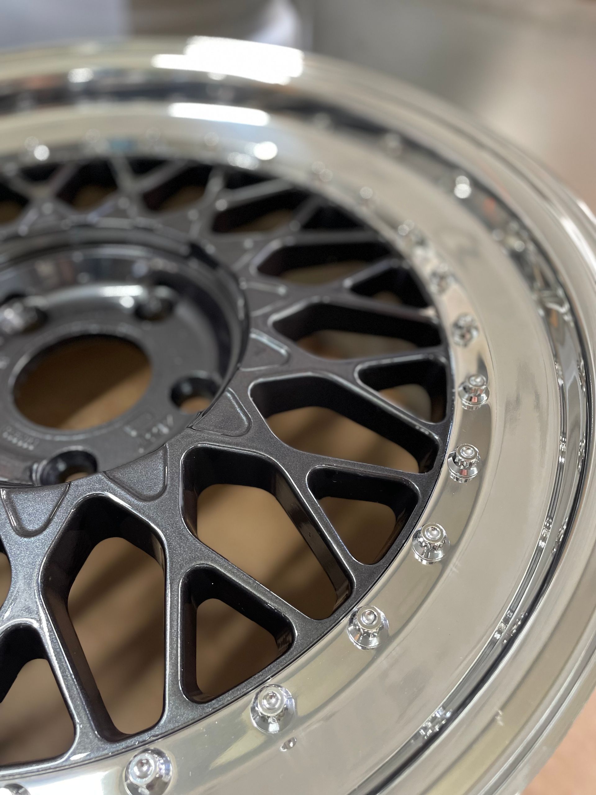 Nahaufnahme einer silbernen Autofelge mit schwarzem Speichenzentrum.