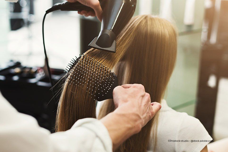Mitarbeiter von DaviDal Hair Design föhnt Haare einer Kundin