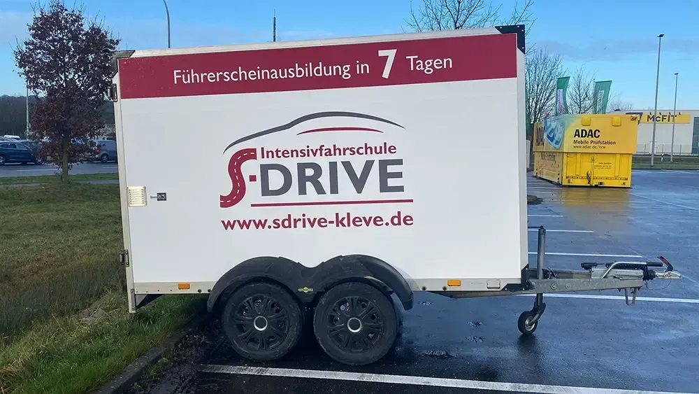 Ein silbernes Yamaha XJ6-Motorrad parkt vor einem weißen Gebäude mit grünem Laubwerk.