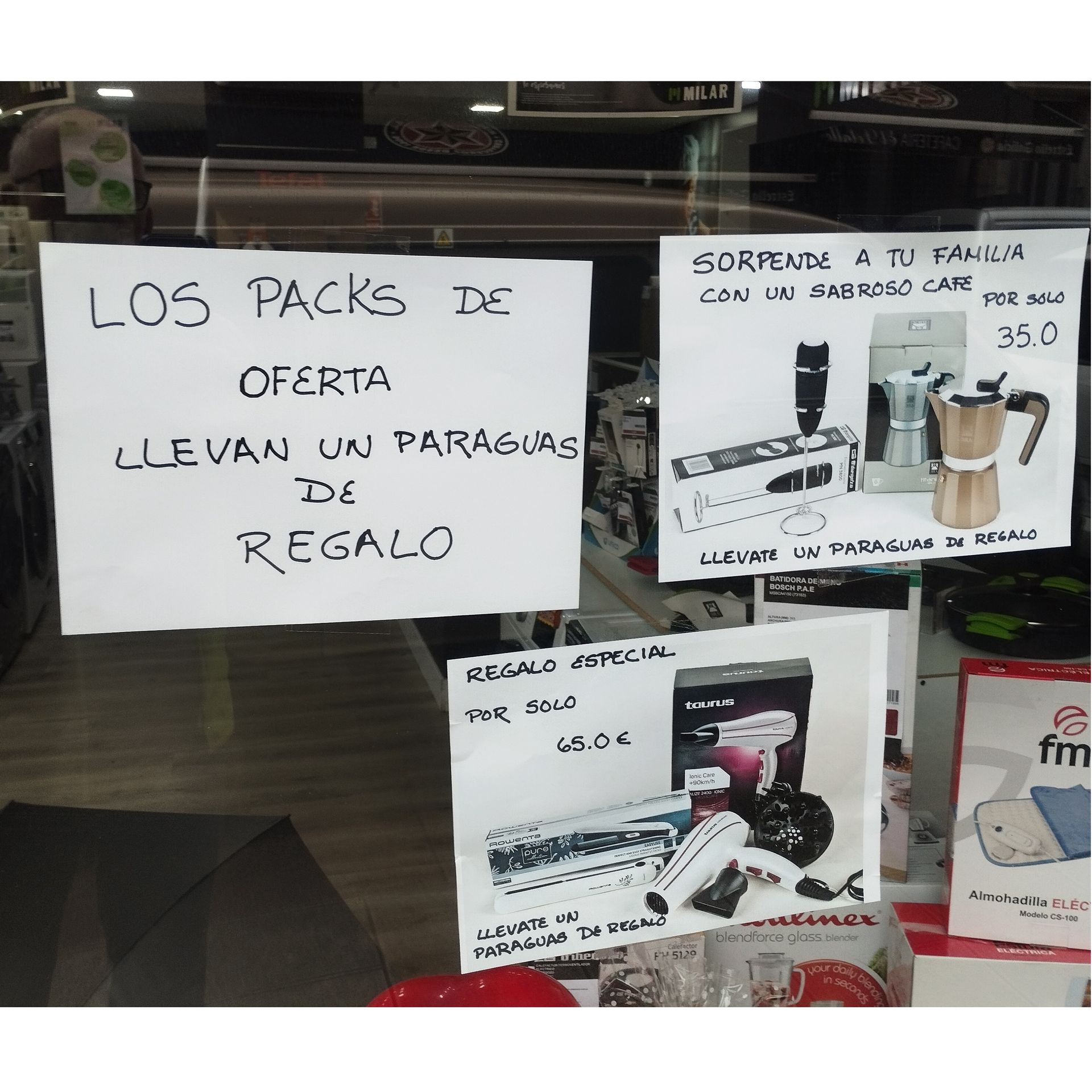 A sign in a store window says los packs de oferta llevan un paraguas de regalo