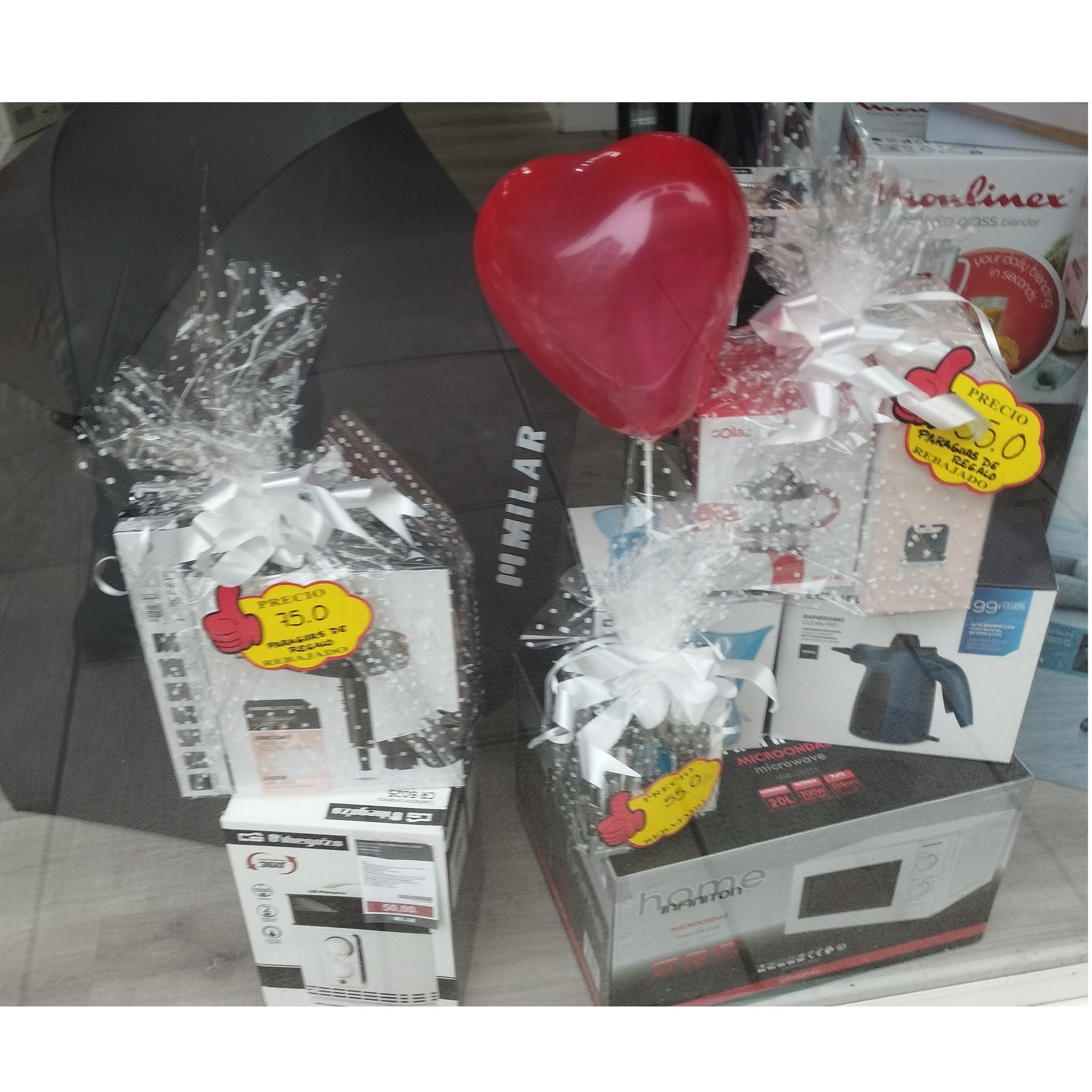 Un globo rojo en forma de corazón está sobre una canasta de regalo.