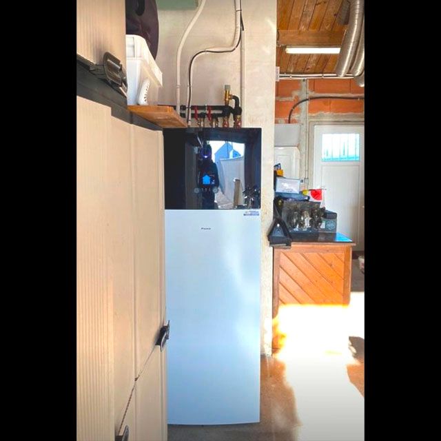 Chaudière au design blanc et noir installée dans un garage par FIEVRE Frères Plombier-Chauffagiste à Jard sur Mer
