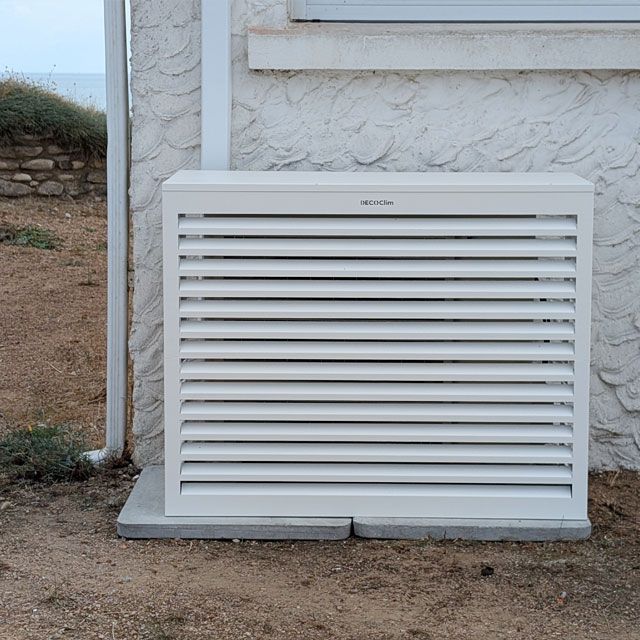 Pose d'un cache climatiseur Décoclim pour une intégration esthétique et discrète dans le jardin, et pour protéger la PAC face aux éléments marins par Fièvre dans une maison de particuliers à Jard sur Mer
