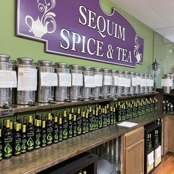 Sequim Spice & Tea shop interior: spices in bins, olive oils, purple sign, green wall.