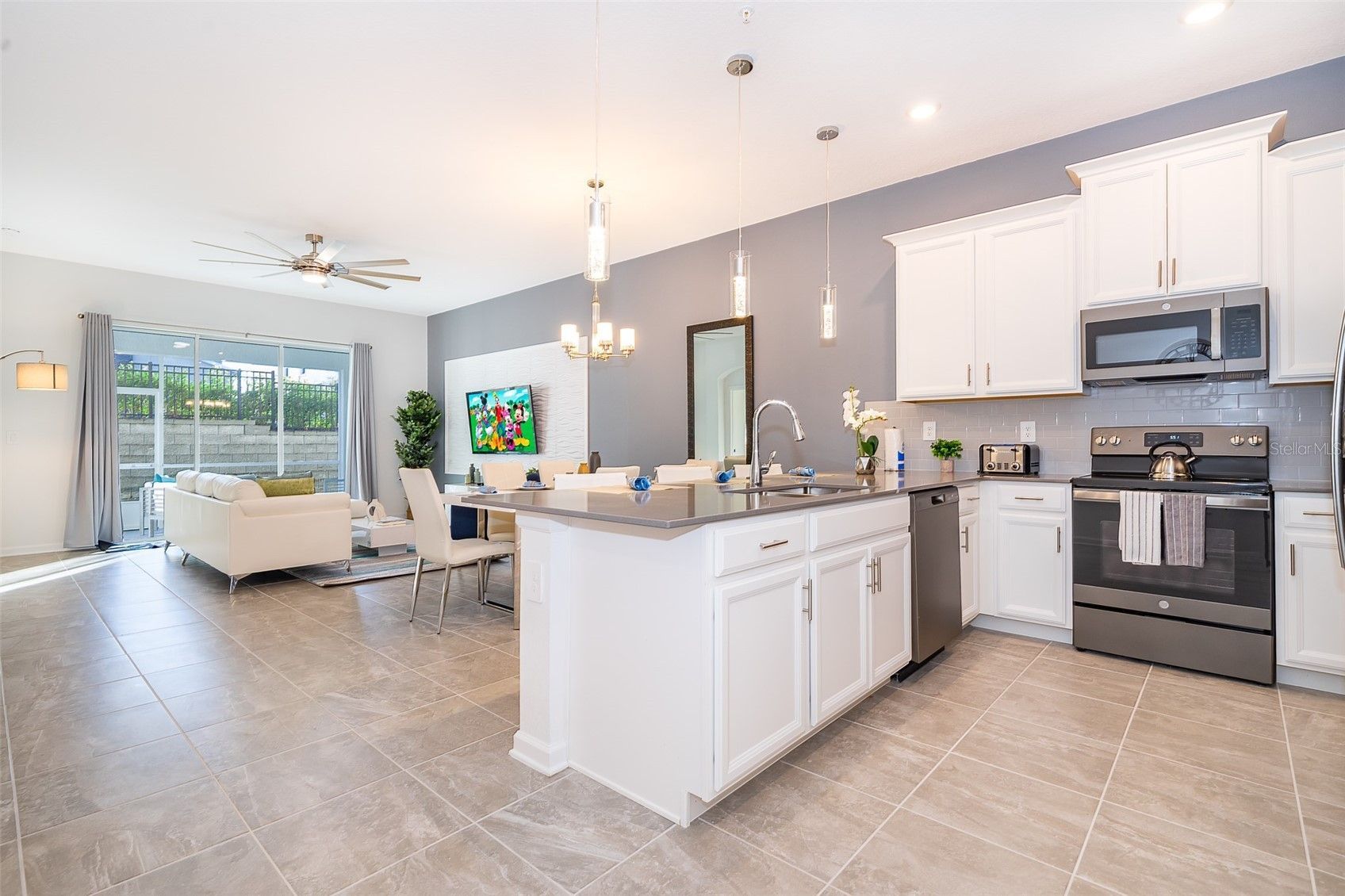 A kitchen in a house with white cabinets and stainless steel appliances.