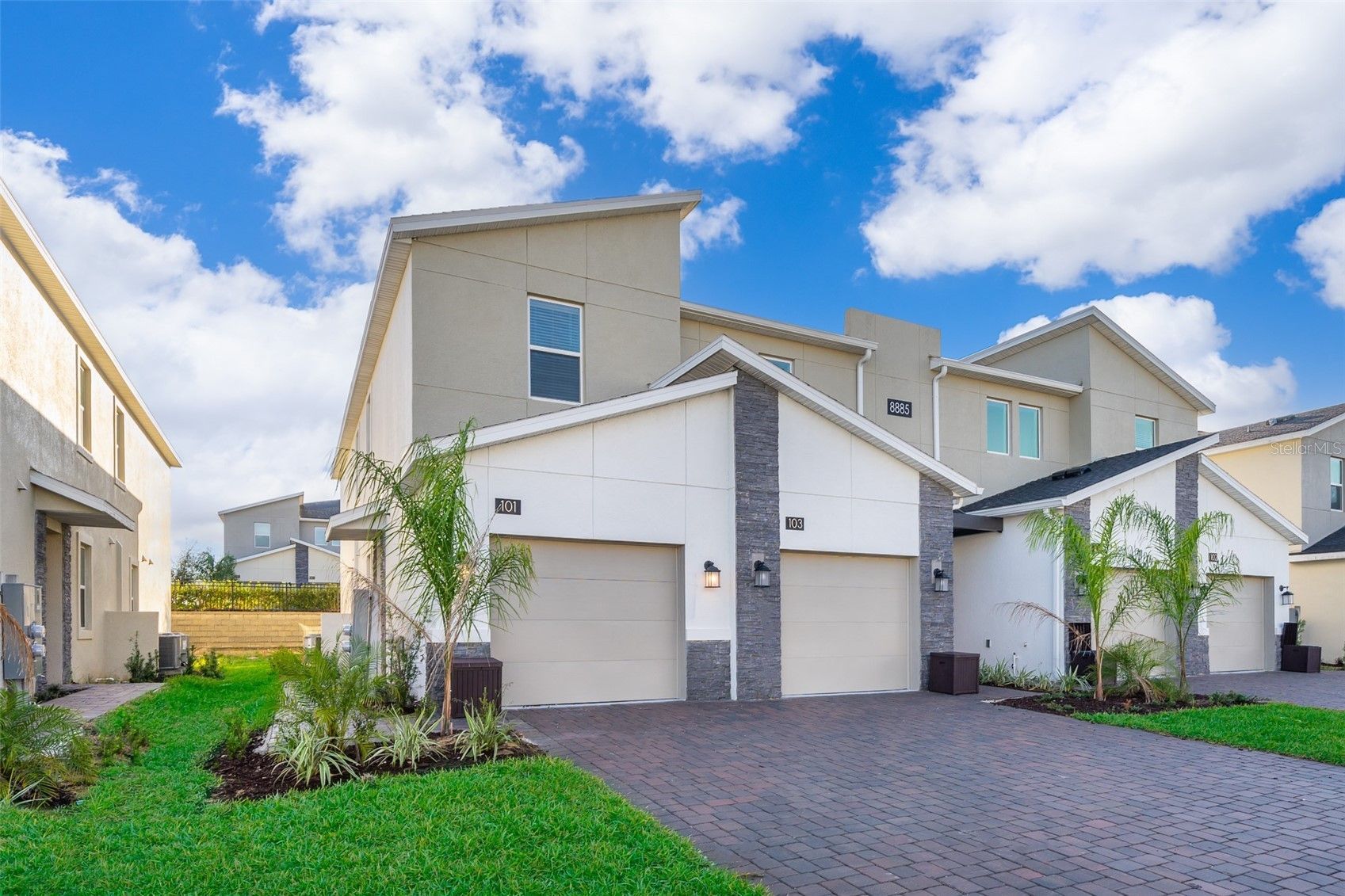 A white house with two garages in a residential area