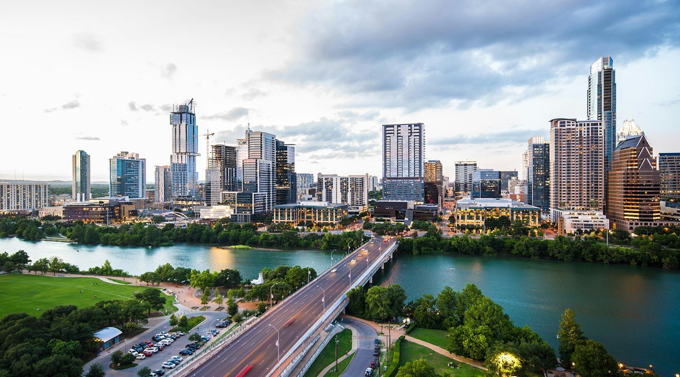 An aerial view of a city skyline with a bridge over a river.