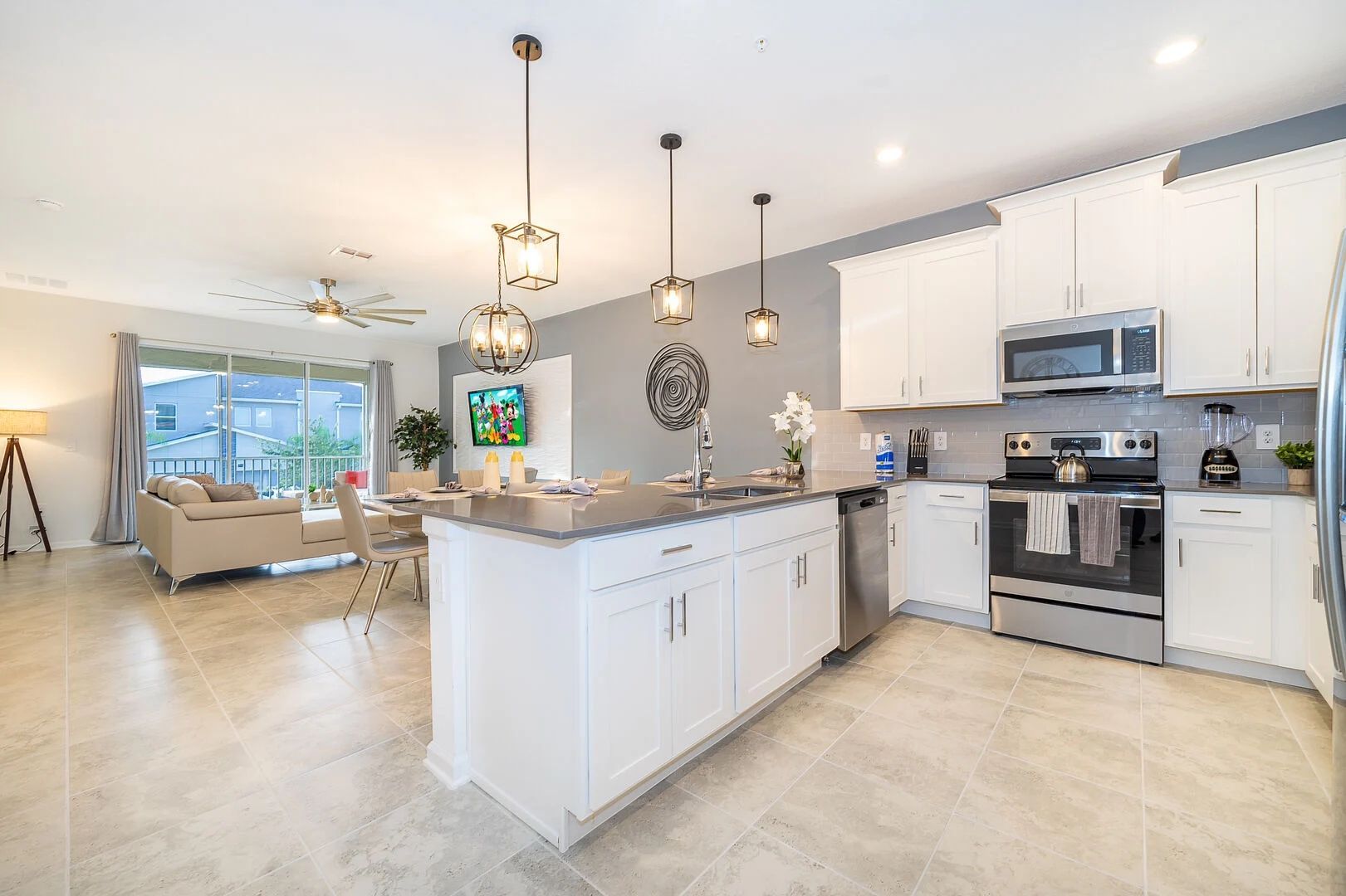 A kitchen with white cabinets , stainless steel appliances , and a large island.