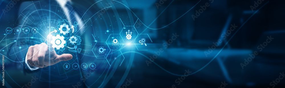 Une personne en costume touche des engrenages lumineux, entourée d'icônes numériques et de lumière bleue.