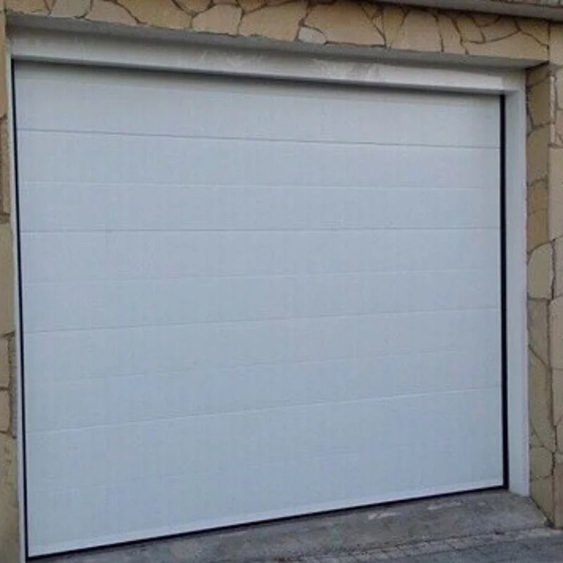 Porte de garage blanche à panneaux horizontaux ; encastrée dans un mur de pierre.