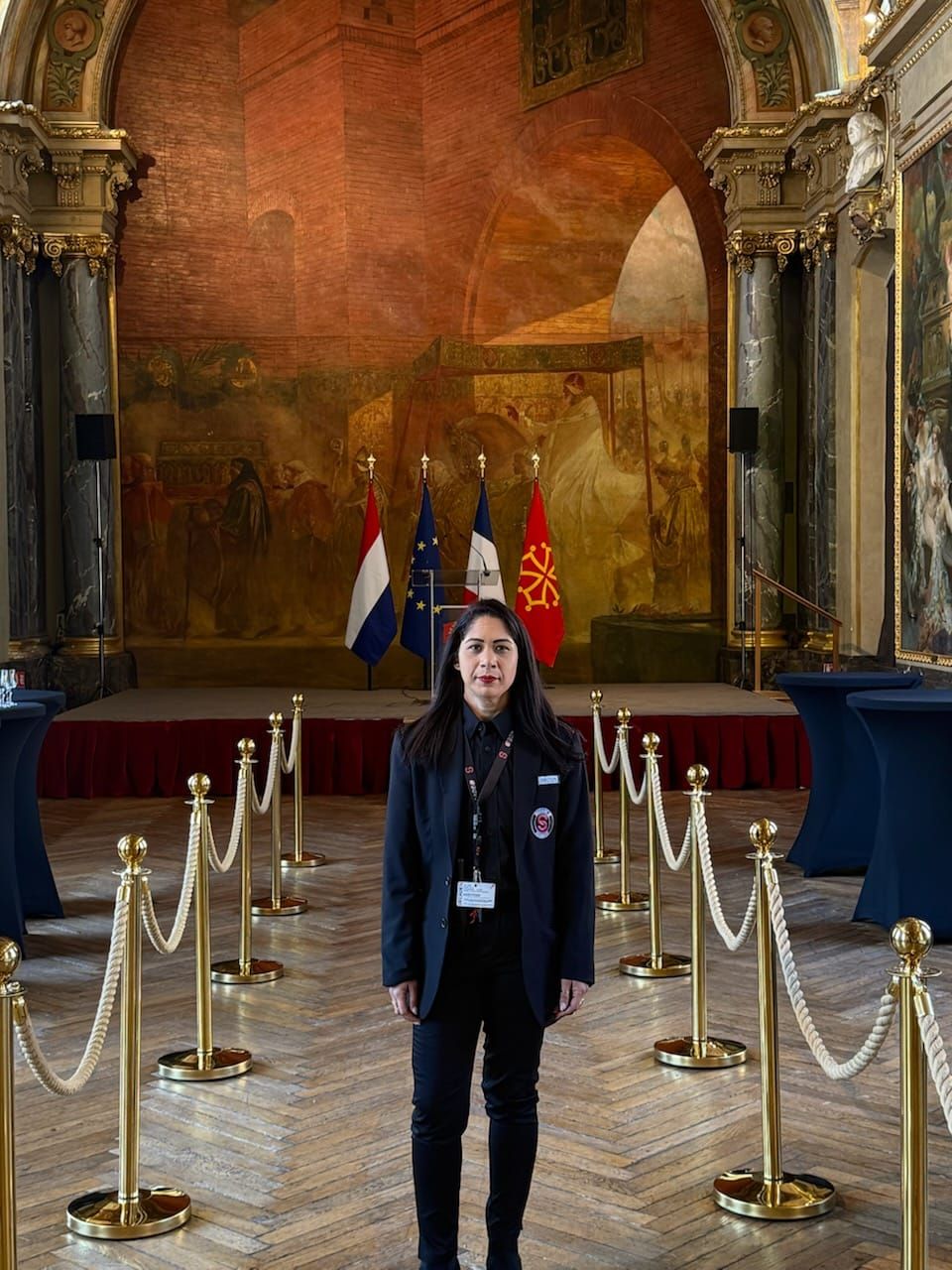 Un homme est scanné par un agent de sécurité avec un détecteur portatif à un portique de détection de métaux.