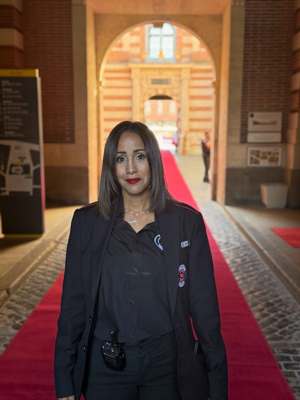 Un homme en costume est fouillé par la sécurité au point de contrôle de l'aéroport avec un détecteur de métaux.