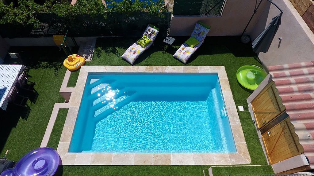 Un jardin avec une piscine et des transats