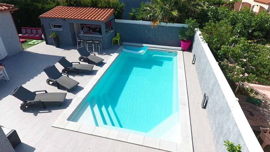 Une terrasse avec des transats et une piscine