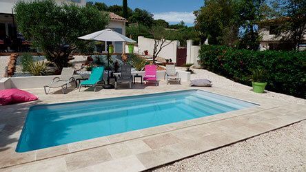 Un extérieur avec un parasol, des transats et une piscine