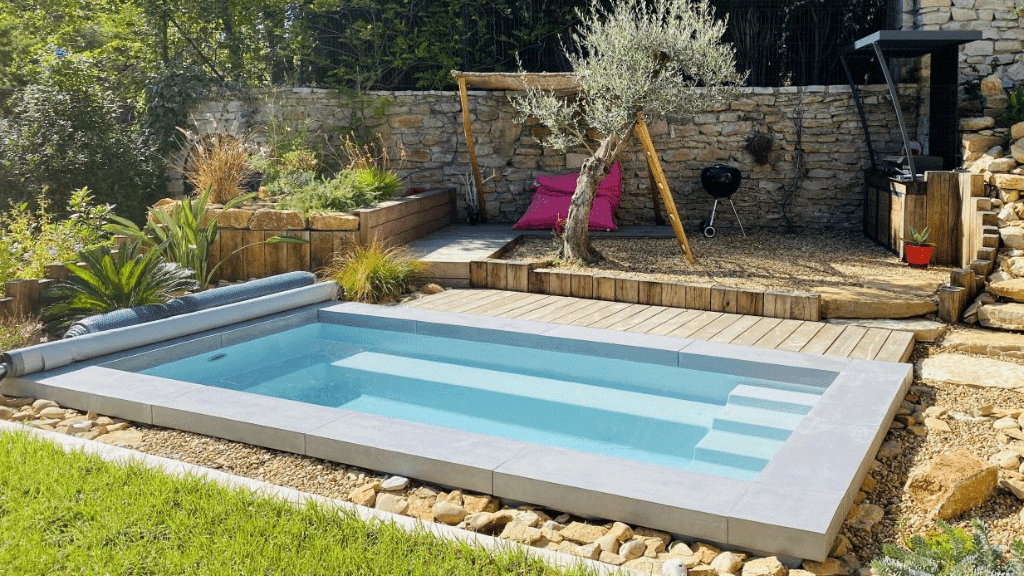 Une petite piscine avec des graviers et des arbustes autour