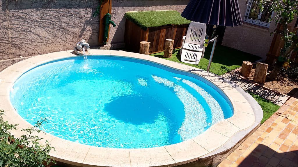 Une piscine de forme ronde avec un parasol et une chaise à côté