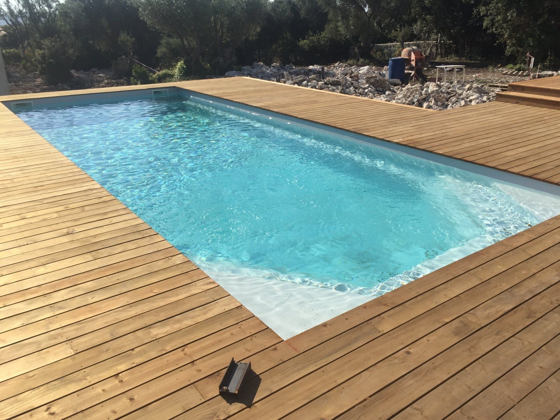 Une piscine avec des planches en bois autour