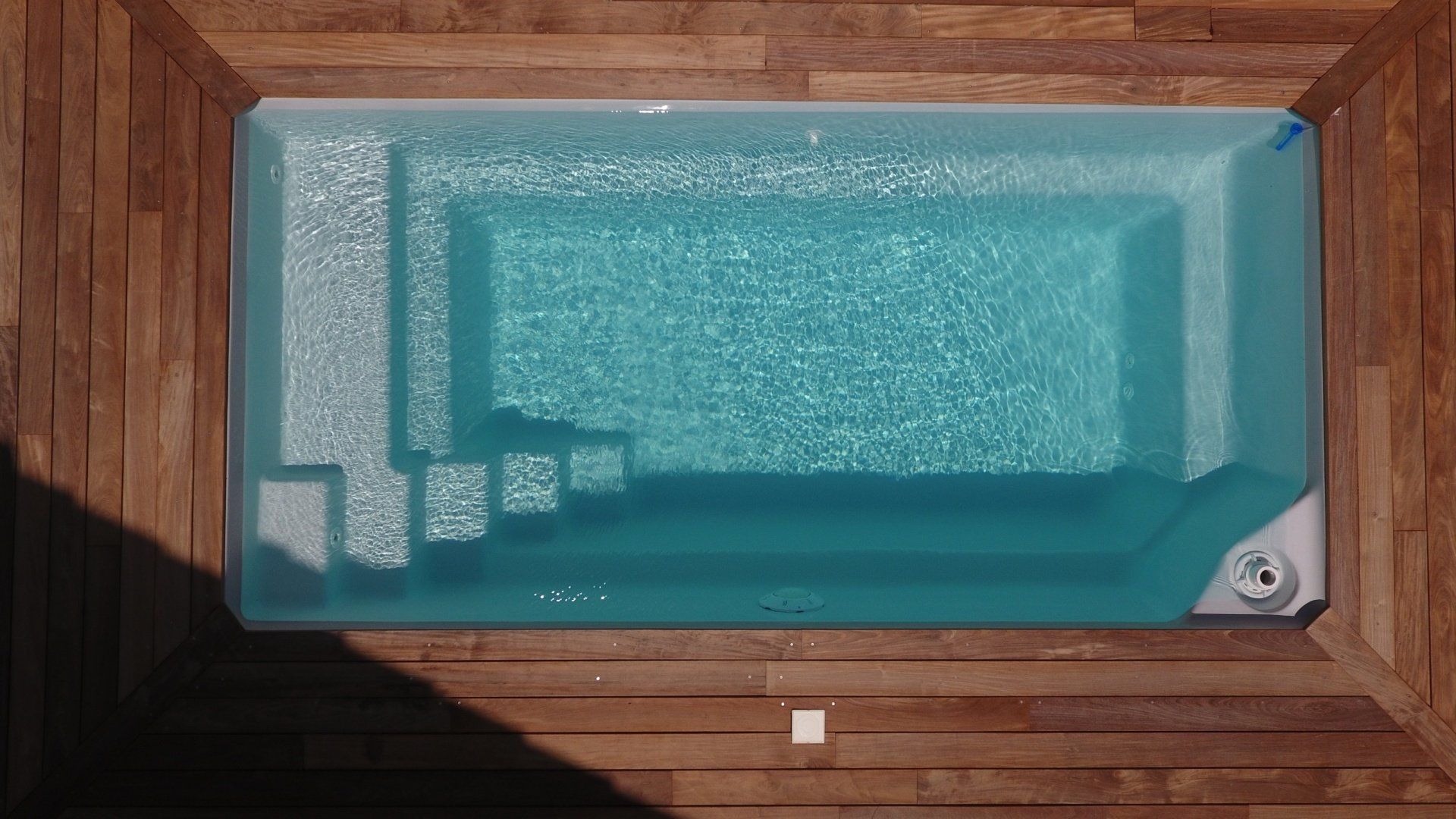 Une vue d'une piscine avec du bois autour