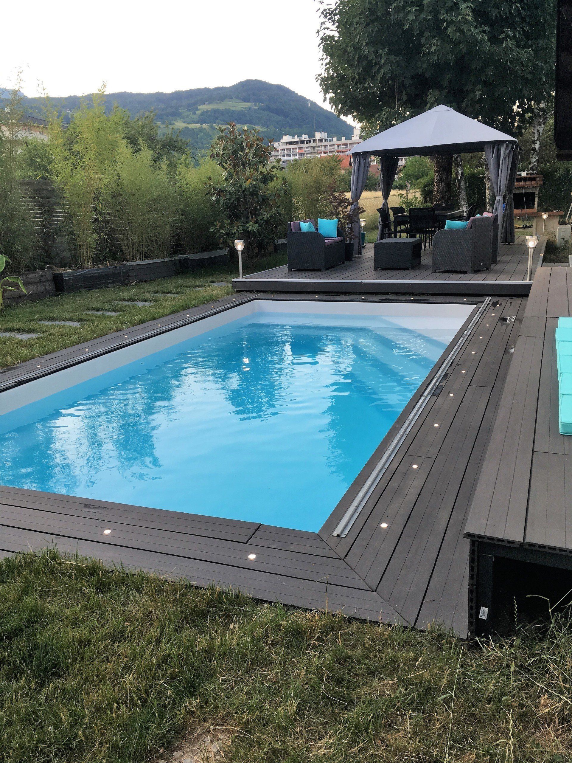 Une piscine avec un éclairage autour, des canapés et un abri