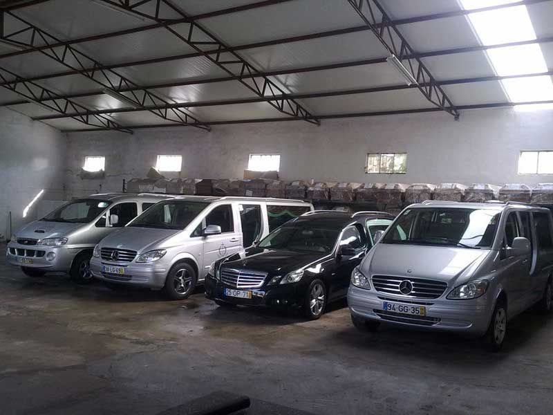 Vários veículos estacionados dentro de um grande armazém aberto.