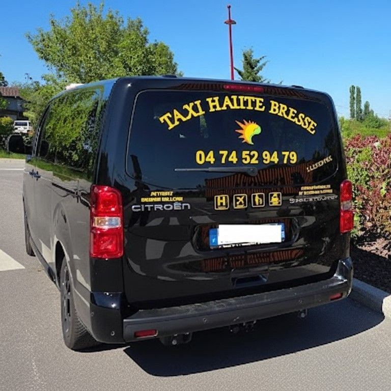 Minibus noir de l'entreprise Taxi Haute Bresse, de la marque Citroën avec inscription jaune garé à l'extérieur sous un ciel bleu