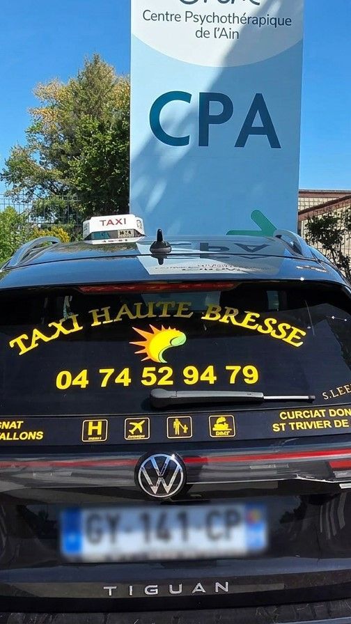 Taxi Volkswagen noir devant un panneau bleu CPA, avec inscription et numéro de téléphone jaunes sur la lunette arrière