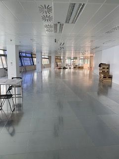 Una gran habitación vacía con una mesa y sillas en ella.