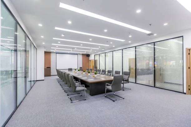 Una gran sala de conferencias con una mesa larga y sillas.