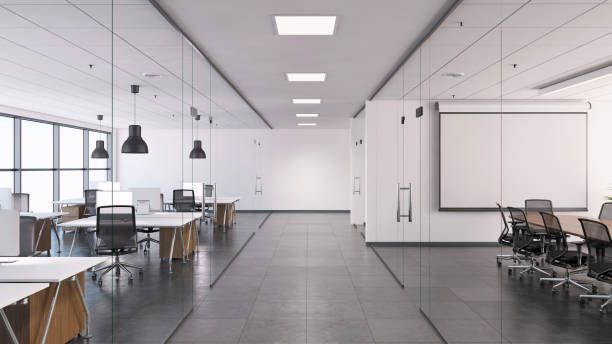 Una oficina vacía con mesas y sillas y una pantalla de proyector.