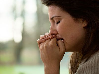 Una mujer se cubre la boca con las manos.