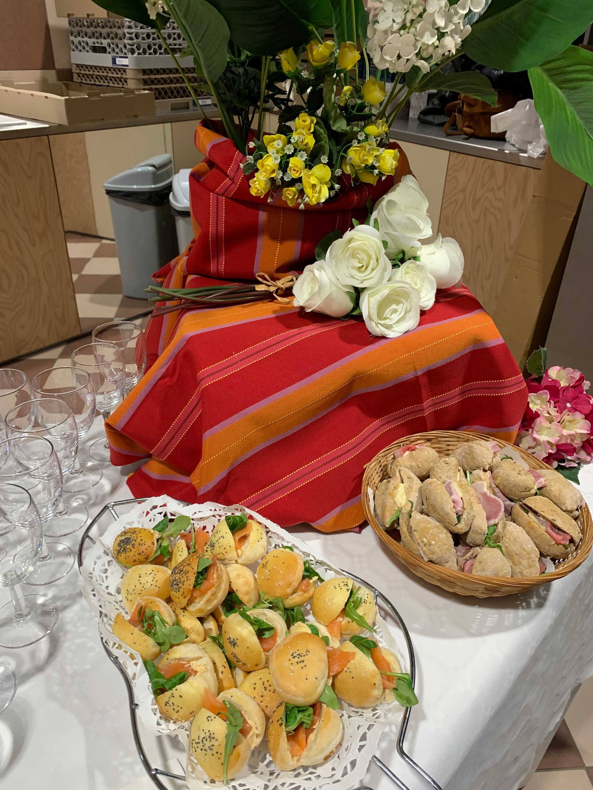 Table avec plats traiteur et verres.
