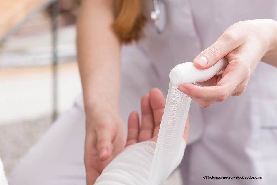 Pflegerin verbindet die Hand einer Person