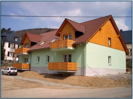 Sonntag Hoch- und Ausbau GmbH Großes Wohnhaus mit Holzverkleidung und minzfarbenem Anstrich