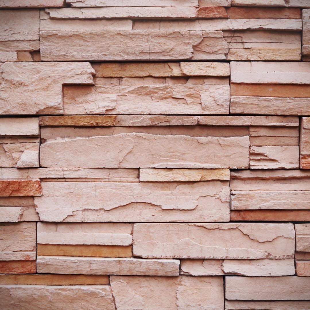 Un primer plano de una pared de ladrillos hecha de ladrillos de diferentes colores.