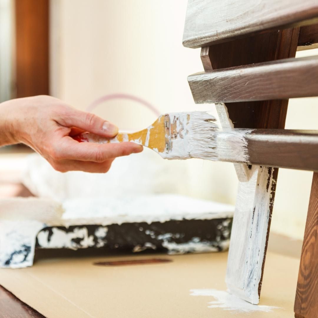 Una persona está pintando un trozo de madera con un pincel.