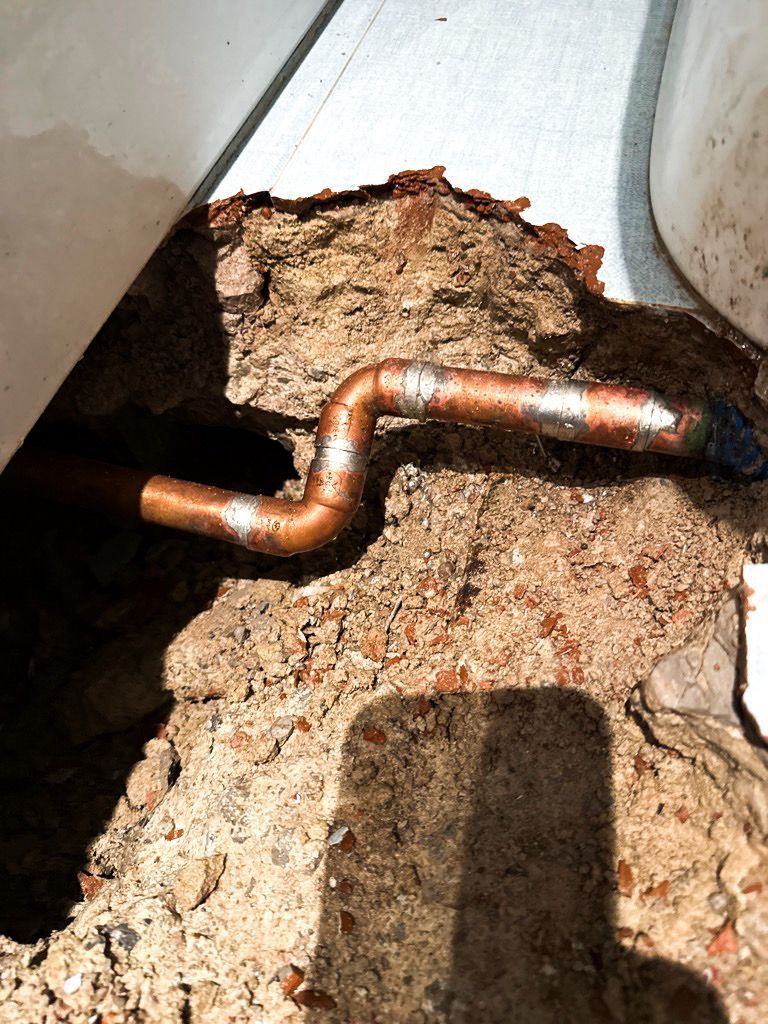 Persona instalando un control de ducha cromado en una pared de baño alicatada.