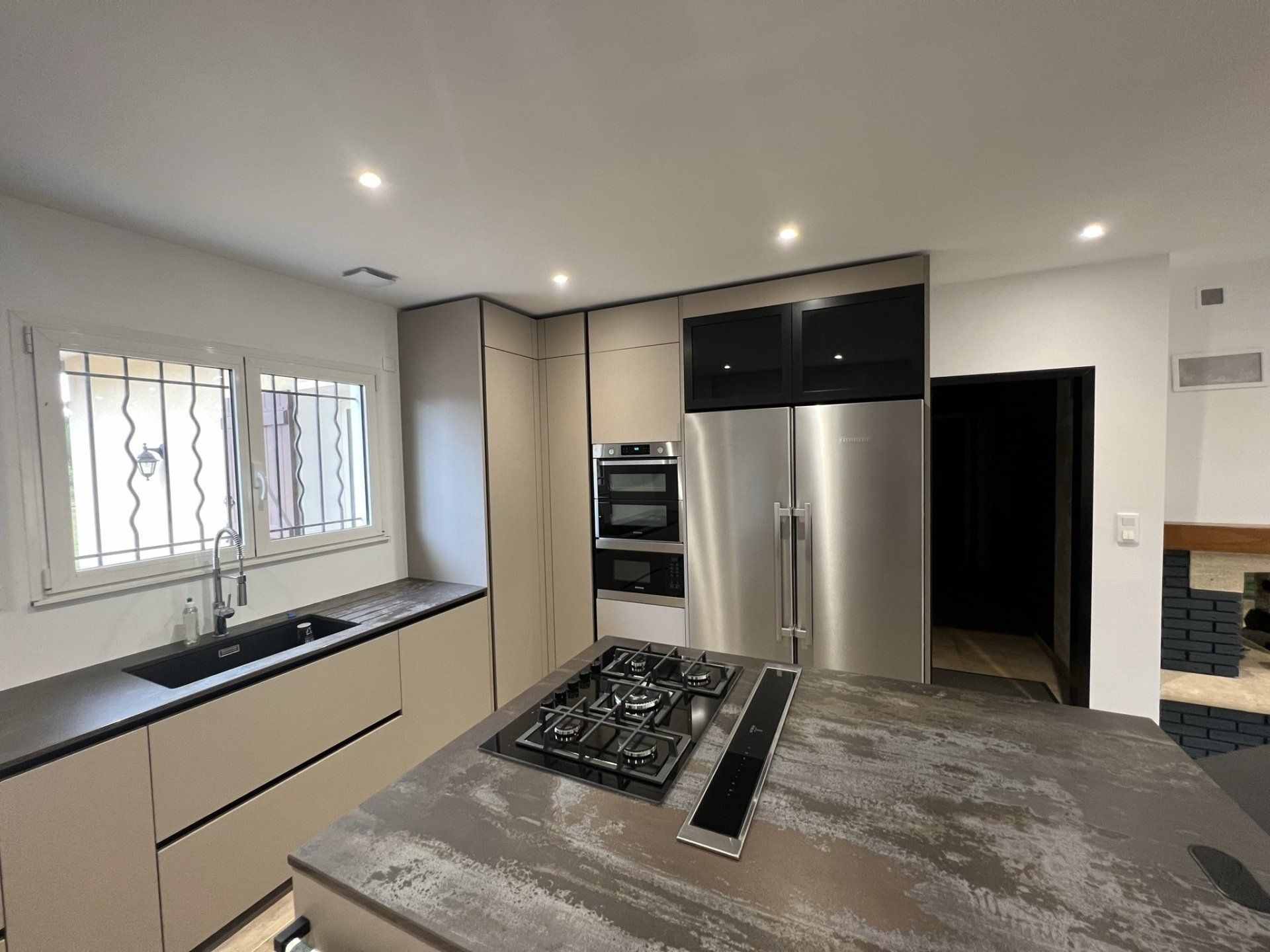 Photo vue large d'une rénovation de cuisine avec îlots central, piano cinq feux.