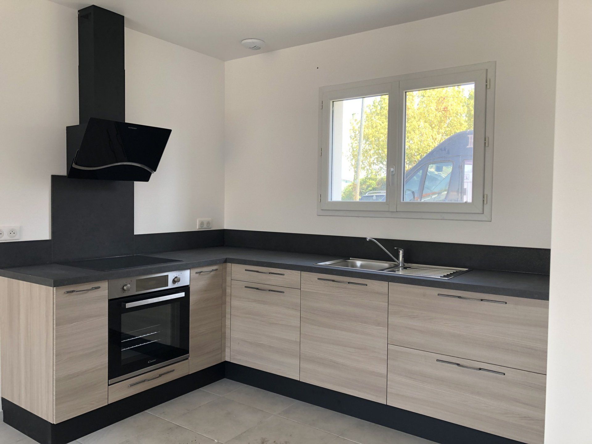 Cuisine en bois et plan de travail en pierre noire.