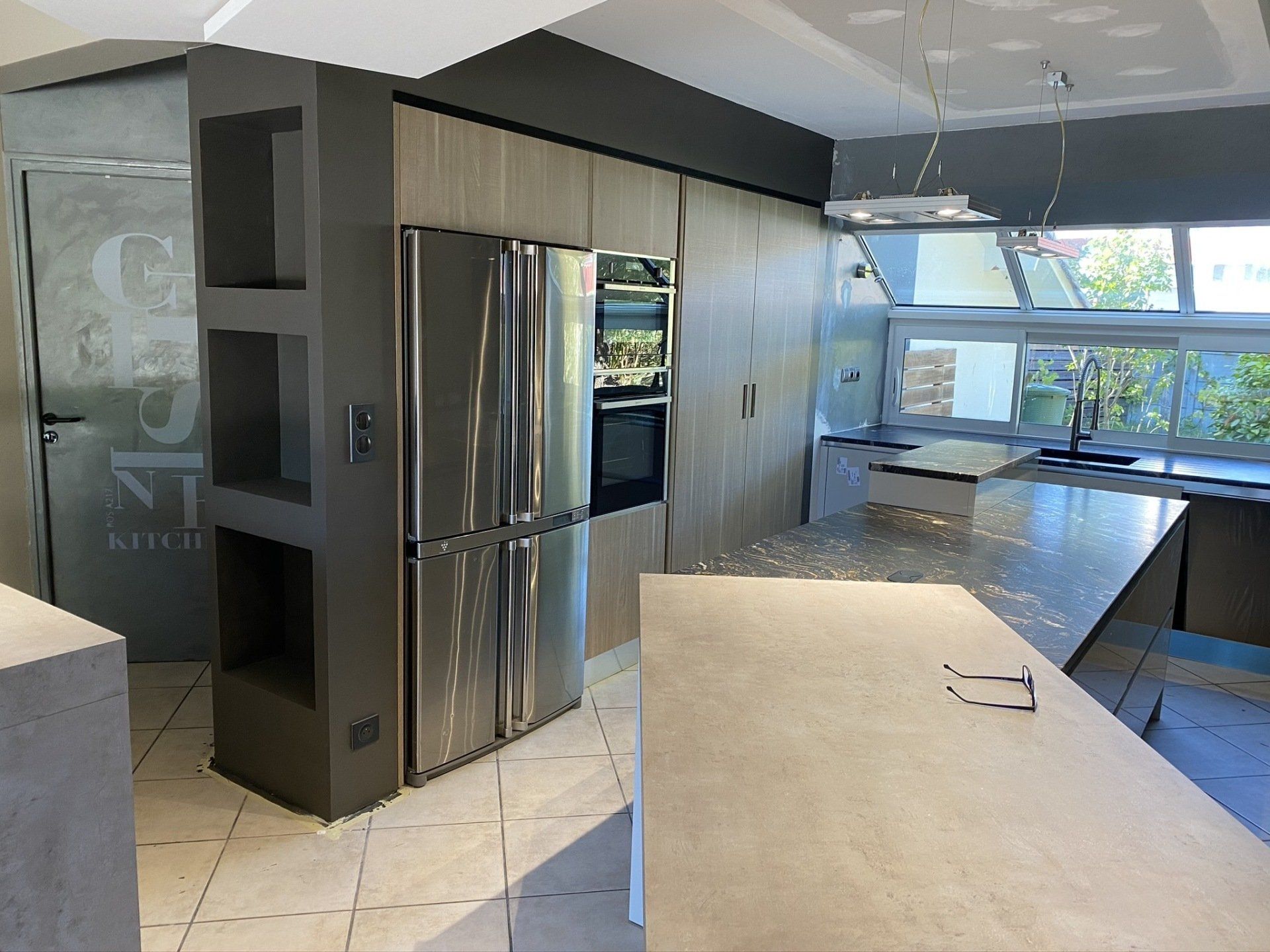 Photo d'une cuisine avec une grande fenêtre devant, très lumineuse