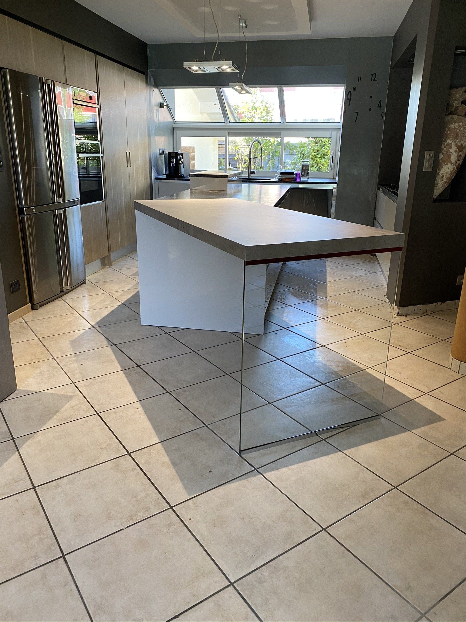 Cuisine lumineuse, avec un îlot central très long et dans grands rangements.