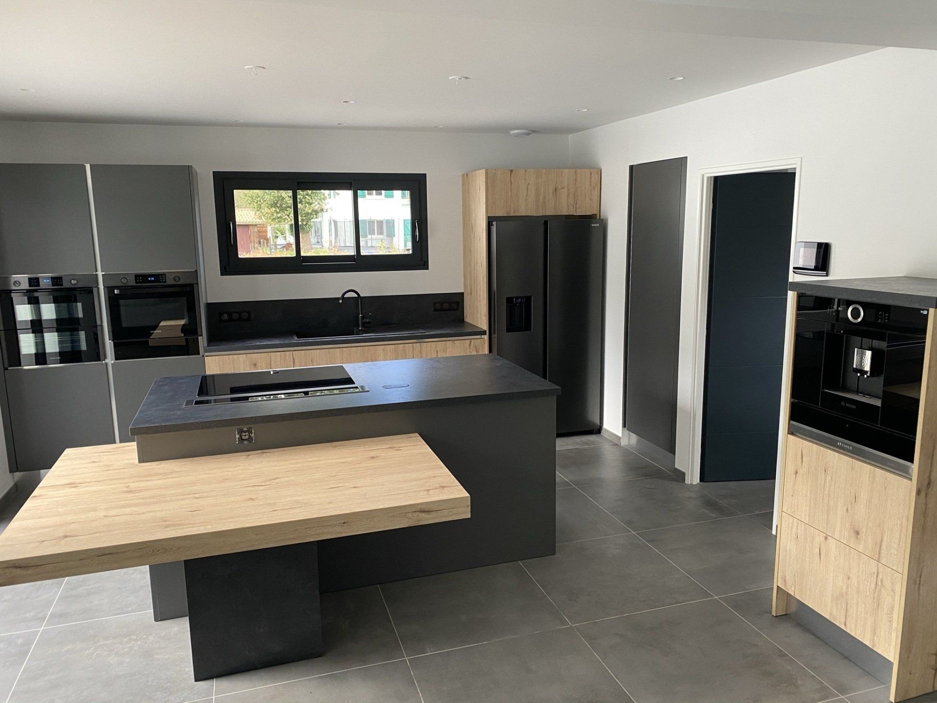 Cuisine moderne en bois avec grand et imposant îlot central, équipé et spacieuse