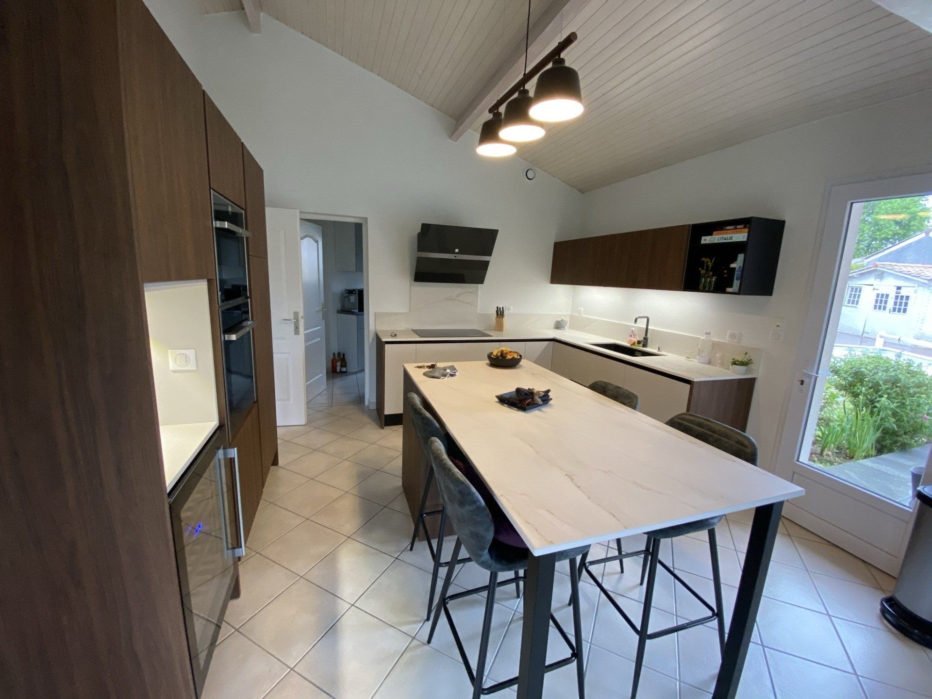 Photo de la pose d'une cuisine avec îlot central et grand meuble de rangement